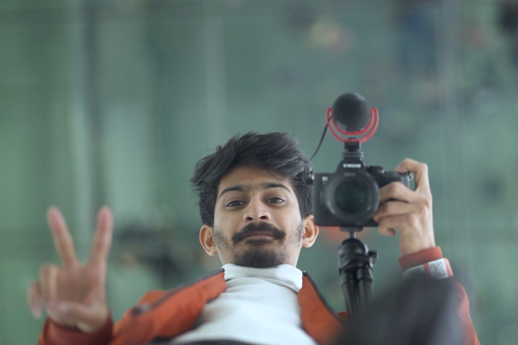 An ASU student looking downwards while holding a camera.